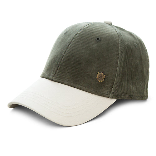 A two-tone baseball cap made of corduroy fabric, featuring an olive green crown and a contrasting off-white curved brim, with a small metallic shield logo on the front.